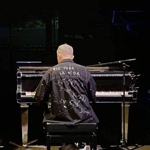 Alejandro Sanz de espaldas tocando el piano